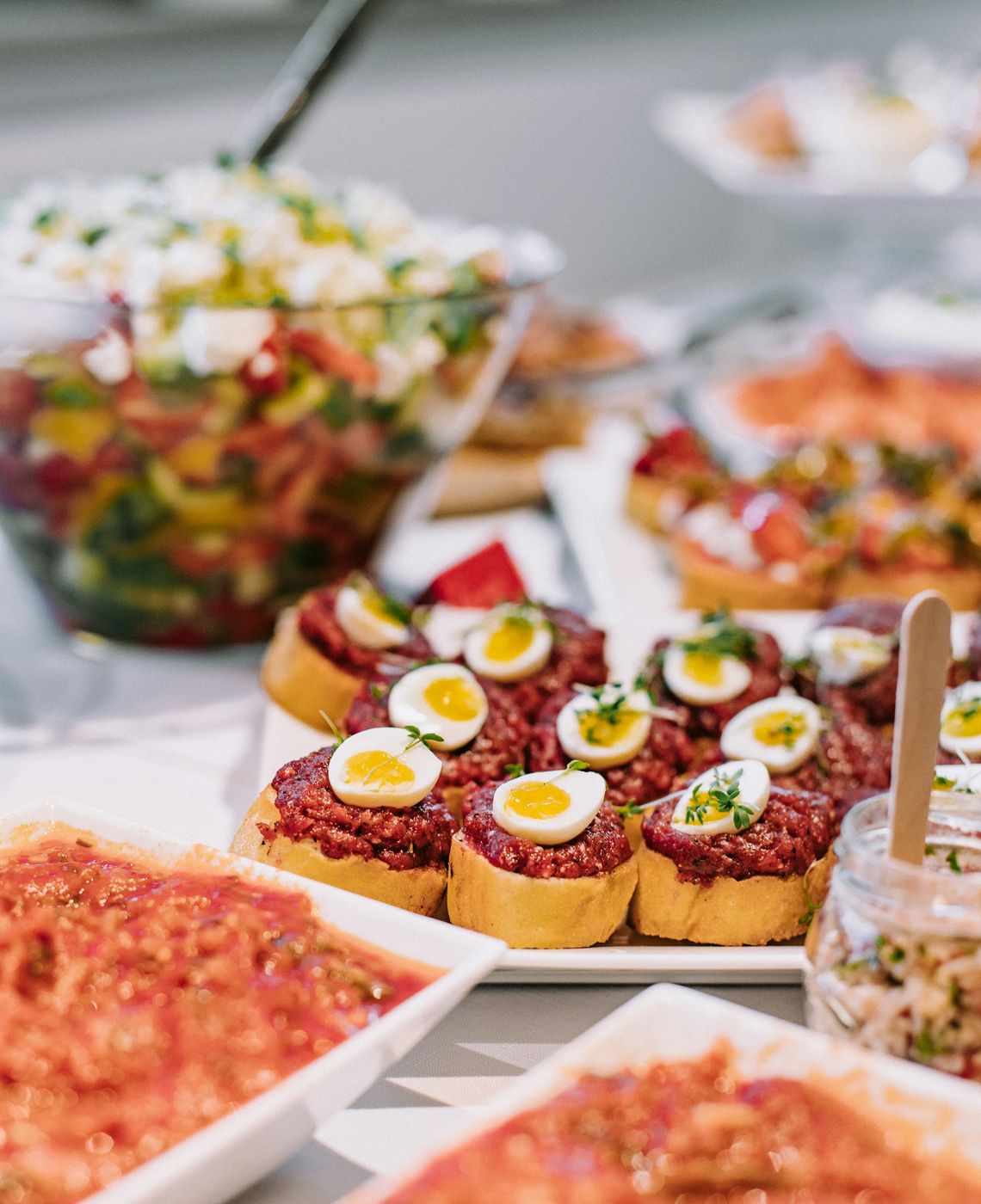 Buffet com saladas coloridas e pequenos salgados