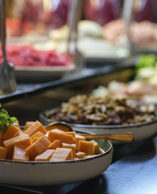 Taças de saladas e queijo numa linha de buffet