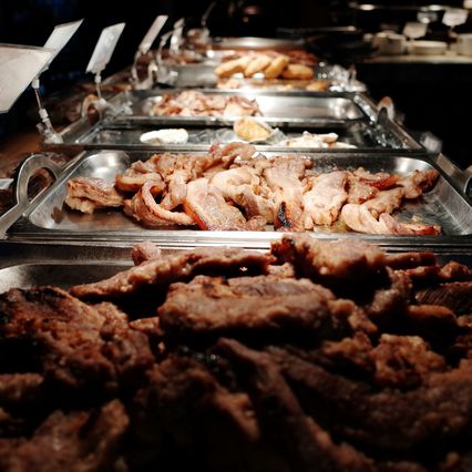 Travessas de carnes grelhadas num buffet