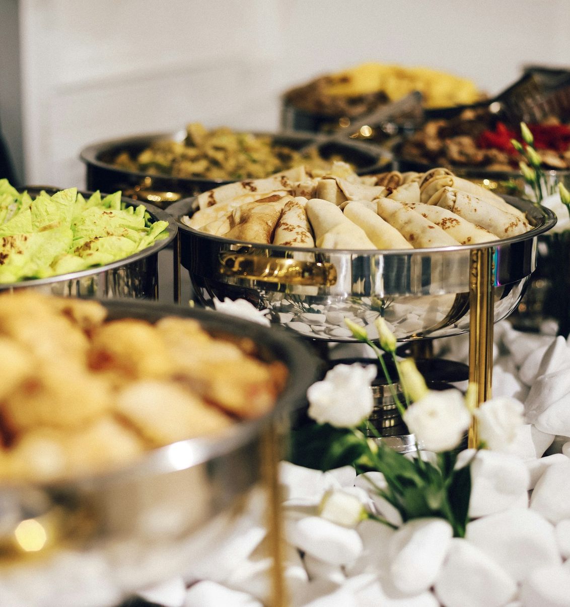 Mesa de buffet com travessas de salgados e pratos quentes
