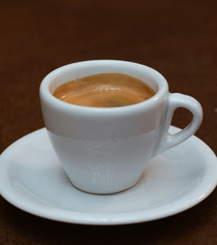 Chávena de café expresso sobre um pires branco