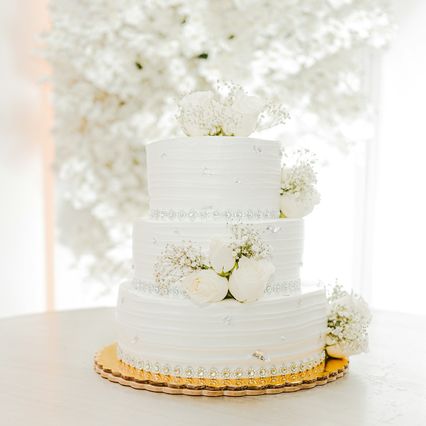 Bolo branco de três andares decorado com flores