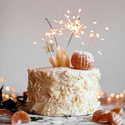 Bolo de festa com chocolate branco e velas faiscantes