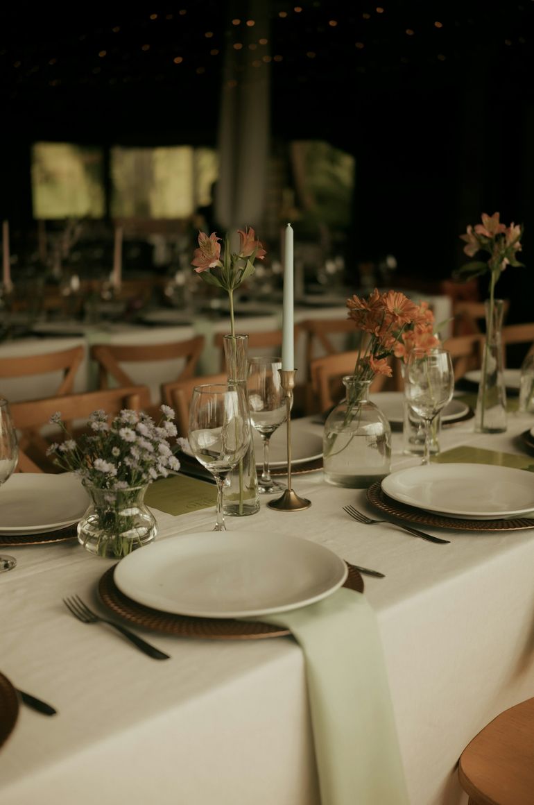 Mesa de festa com pratos, velas e flores do campo