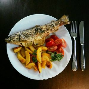 Peixe inteiro assado, com batatas e tomate