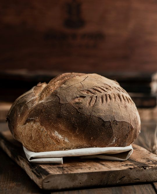 Pão de crosta estaladiça sobre uma tábua de madeira