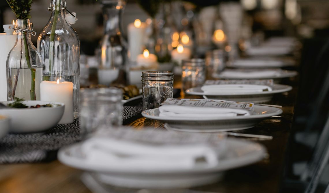 Mesa posta com pratos, guardanapos de linho e velas