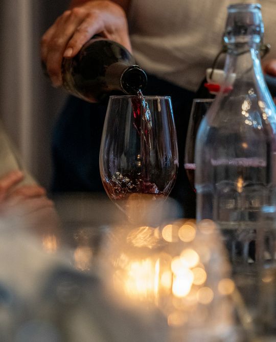 Vinho tinto a ser servido à luz das velas