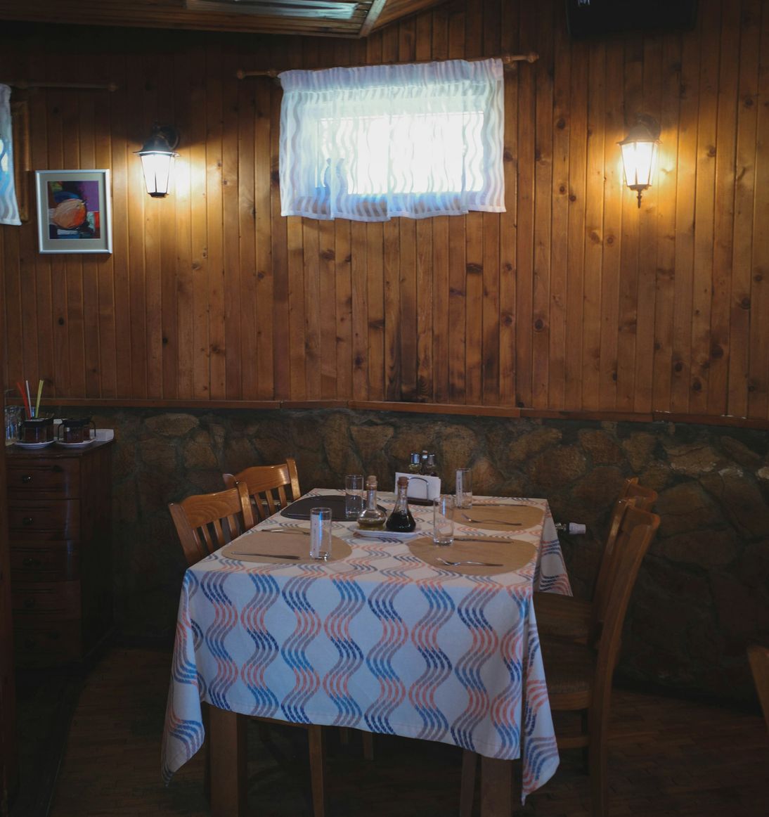 Sala de refeições acolhedora, com paredes de madeira e uma mesa posta